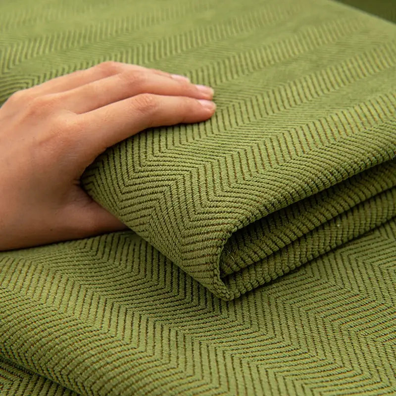 Olive green chenille textured non-slip sofa cover fabric folded and held by hand for living room sofa cushion use
