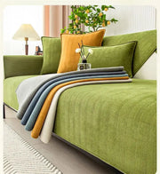 A set of five chenille textured throw blankets in muted colors on an olive-green sofa with a non-slip sofa cover