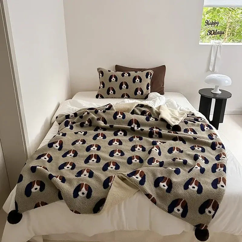Soft beige rollie loop fleece blanket with playful basset hound faces and pom-poms for cozy bedroom use