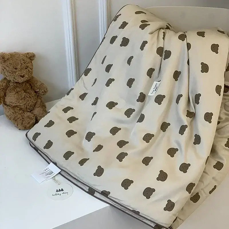 Cream-colored decorbites cooling quilt with brown teddy bear pattern and soft fabric for a restful night’s sleep