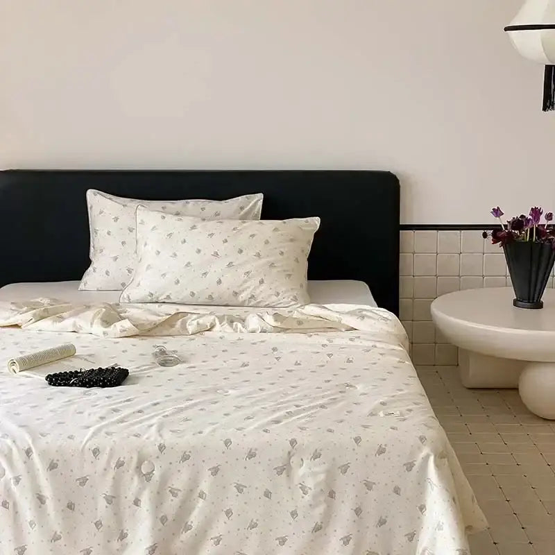 Cream-colored satin duvet cover with subtle gray floral pattern paired with decorbites cooling quilt for night’s sleep