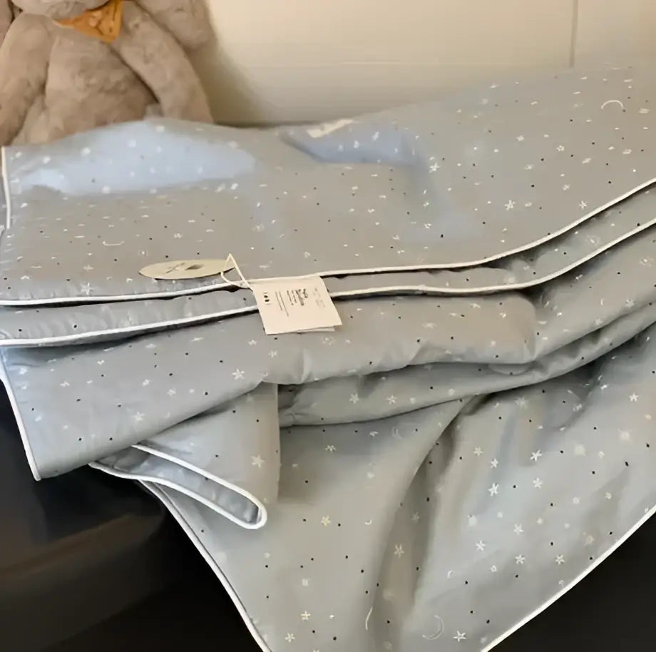 Gray star-patterned cooling quilt with white stitching and plush texture for a comfortable night’s sleep by decorbites