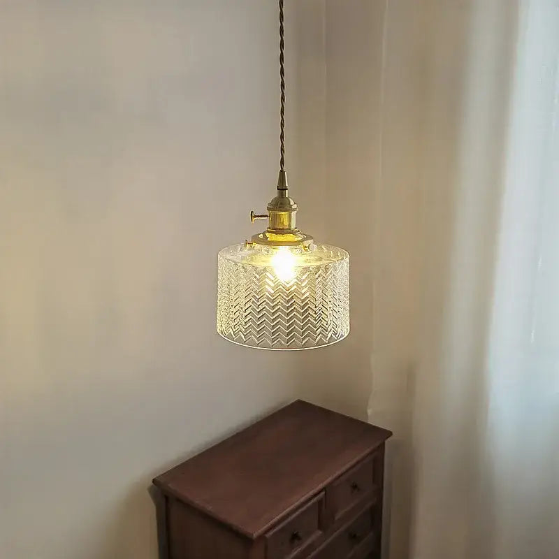 A warm-toned vintage pendant light with green glass chevron pattern and brass hardware for kitchen hanging lamp