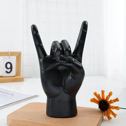 Chic black glossy resin hand gesture sculpture making a rock gesture ideal for living room decor