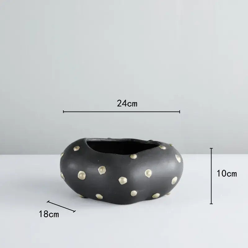 Black resin flower pot with rounded organic shape and gold accent by decorbites for elegant living room decor