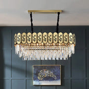 Gold island crystal shaded hanging lamp with gold-toned frame, black cords, and clear crystal prisms on decorative panel