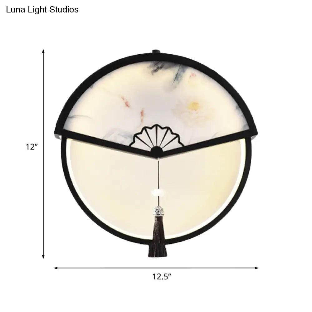 Lámpara de pared LED china de metal negro en forma de abanico con mural de escena de montaña y detalle de borla.