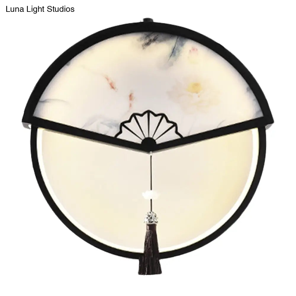 Lámpara de pared LED china de metal negro en forma de abanico con mural de escena de montaña y detalle de borla.