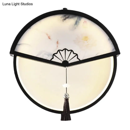 Lámpara de pared LED china de metal negro en forma de abanico con mural de escena de montaña y detalle de borla.