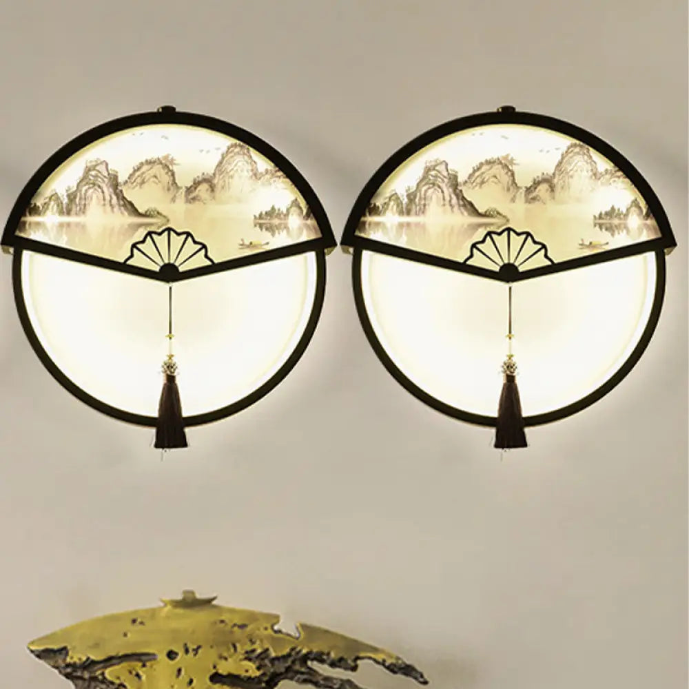 Lámpara de pared LED china de metal negro en forma de abanico con mural de escena de montaña y detalle de borla.