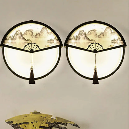 Lámpara de pared LED china de metal negro en forma de abanico con mural de escena de montaña y detalle de borla.