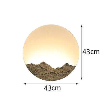 Circular wall light with warm amber glow and textured bronze chinese mountain silhouette by decorbites led wall light