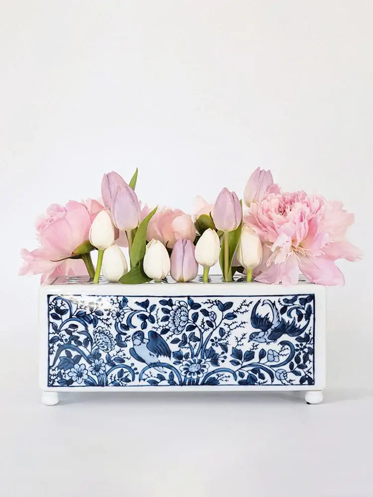 A rectangular white porcelain flowerpot vase with blue and white floral bird pattern holding pink tulips and peonies decorbites blue white