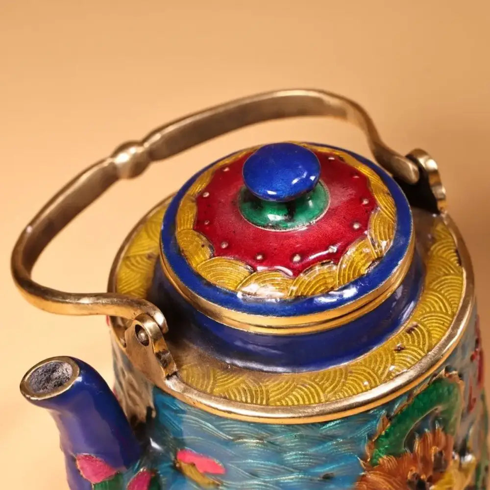 A vibrant hand-painted enamel pan teapot with blue lid knob gold-trimmed handle featuring decorbites dragon cloisonné design