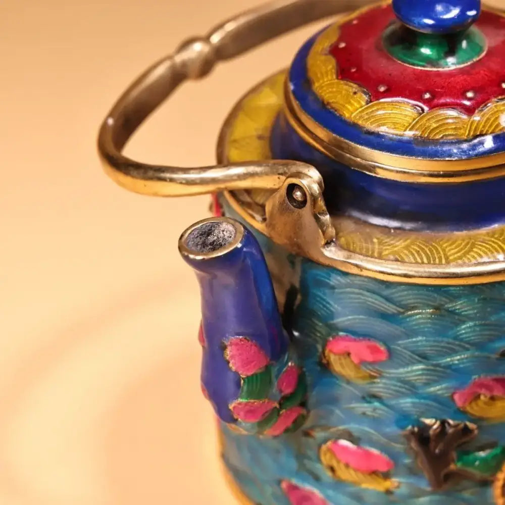 A vibrant blue and gold enamel pan teapot with pink lotus flowers and wave patterns from decorbites dragon cloisonné