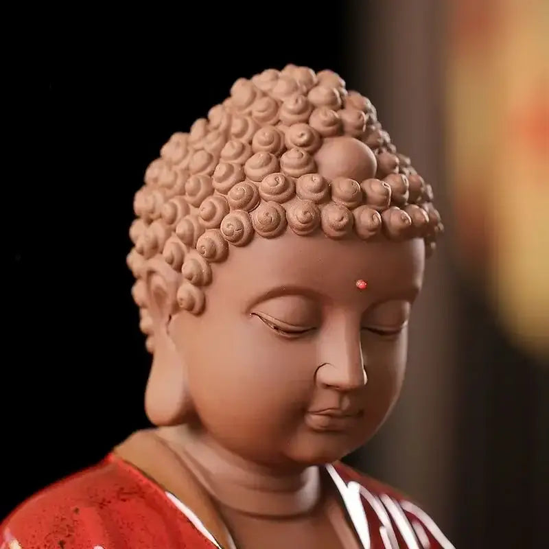Tan clay ceramic sakyamuni buddha statue with spiral curls and red dot wearing red robe for living room decor