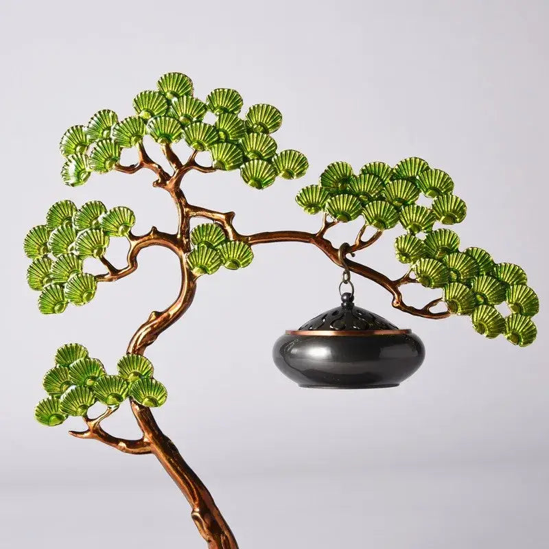 Bronze metal bonsai sculpture with vibrant green enamel pine leaves and a hanging black incense burner for living room use