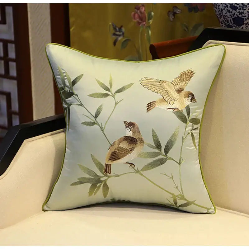 A light green square pillow cover with birds branches embroidered in earthy tones for living room decorbites decor