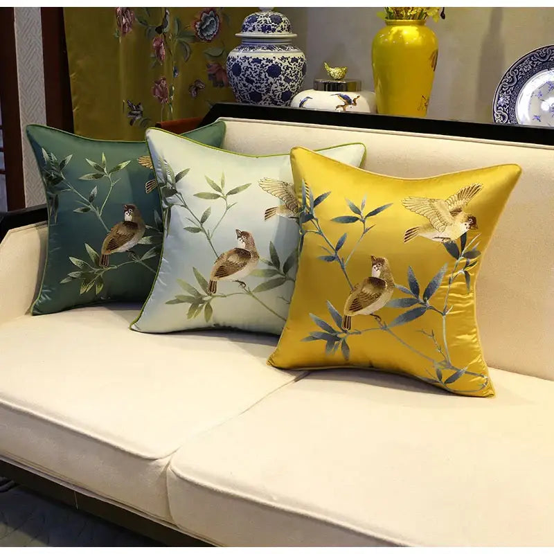 Three embroidered satin pillow covers in green light blue and yellow with birds branches decorbites birds branches motifs