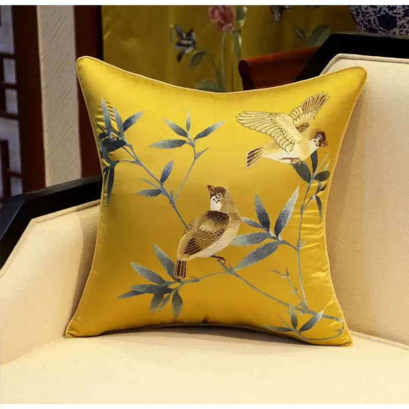 A golden yellow silk pillow cover with birds branches embroidered in chinoiserie style for living room decor