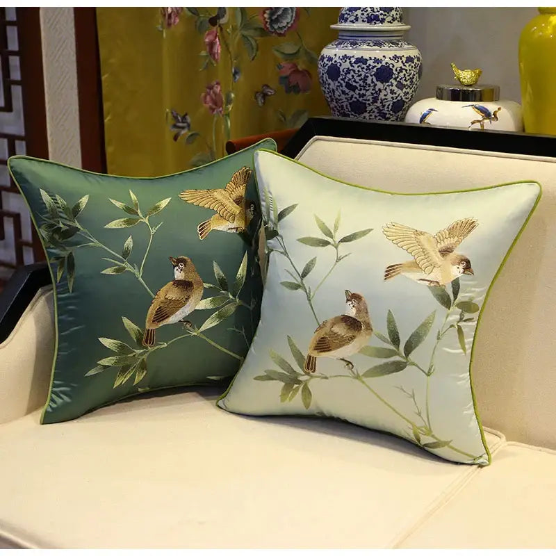 Two square embroidered pillow covers in deep green satin and pale mint silk with birds branches embroidered design