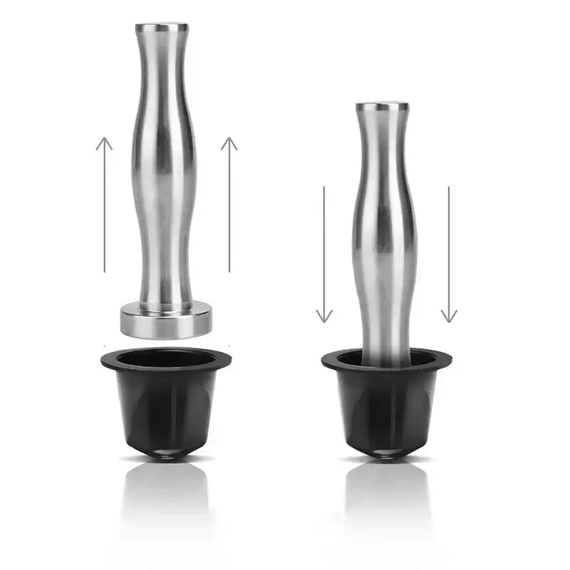 Stainless steel espresso tamp with a sleek tapered handle and circular base next to a chrome cylindrical coffee pod holder organizer