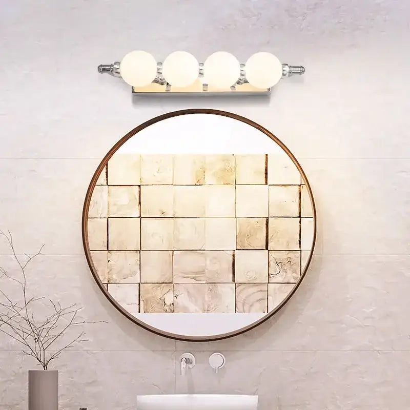 Round mirror with dark wood frame and beige textured tile mosaic reflecting bathroom wall paired with decorbites bubble ball wall sconces