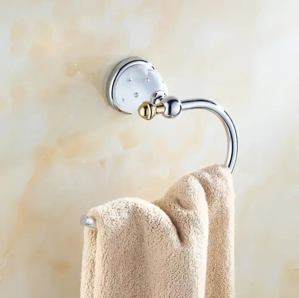 Chrome and gold ceramic bathroom hardware set towel rack with decorative studs holding a beige textured towel from decorbites bathroom hardware