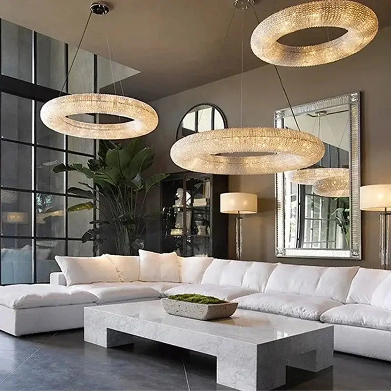 Three elegant decorbites chrome round crystal chandeliers with sparkling design hang in a living room setting