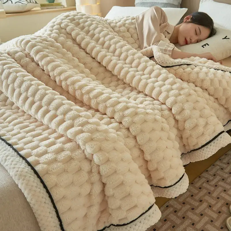 Cream-colored plush chunky knit coral fleece blanket with black trim for bedroom use and cozy warmth