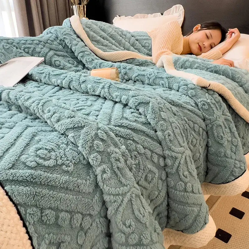 A plush teal coral fleece blanket with raised floral pattern and cream-colored inner lining for bedroom throw