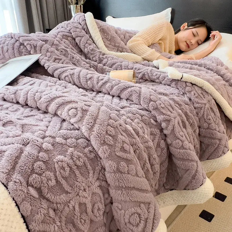 A lavender coral fleece blanket with raised floral pattern and soft white lining ideal as a bedroom throw