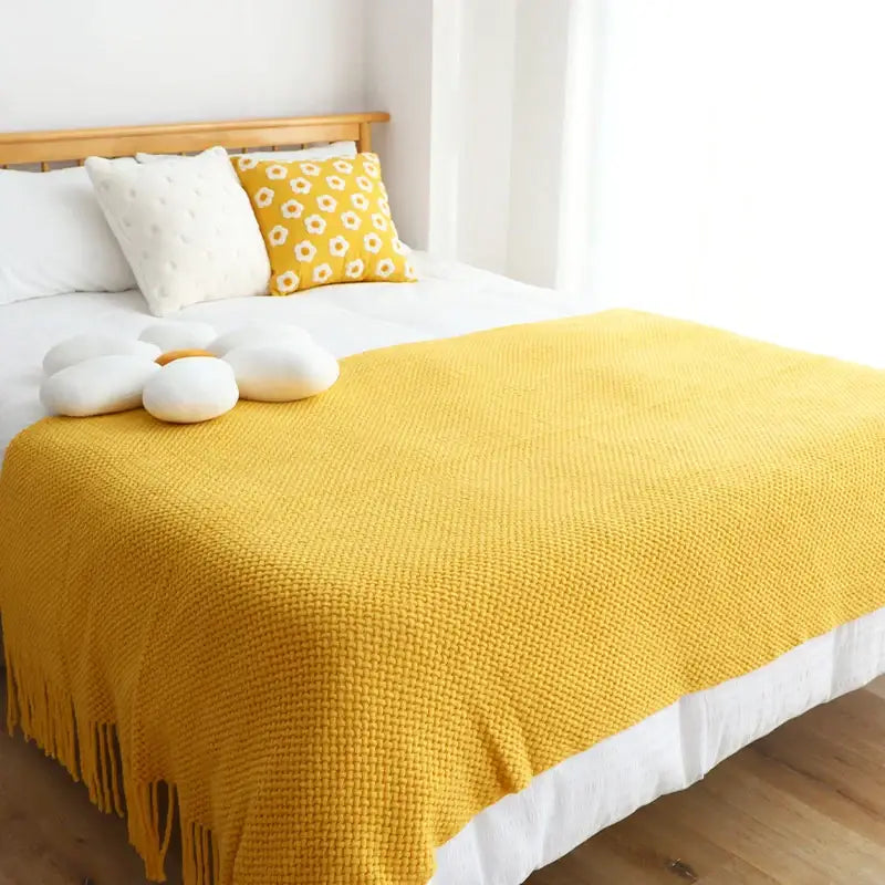 A cozy mustard-yellow decorbites knitted leisure blanket throw with textured weave and tassels for bedroom decor