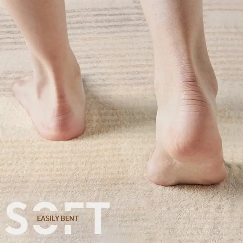 Bare feet standing on a beige decorbites circular geometric cashmere floor mat soft textured living room carpet