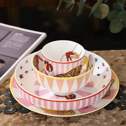 A vibrant pink and white ceramic tableware set with circus troup kids whimsical tiger and acrobat illustrations by decorbites