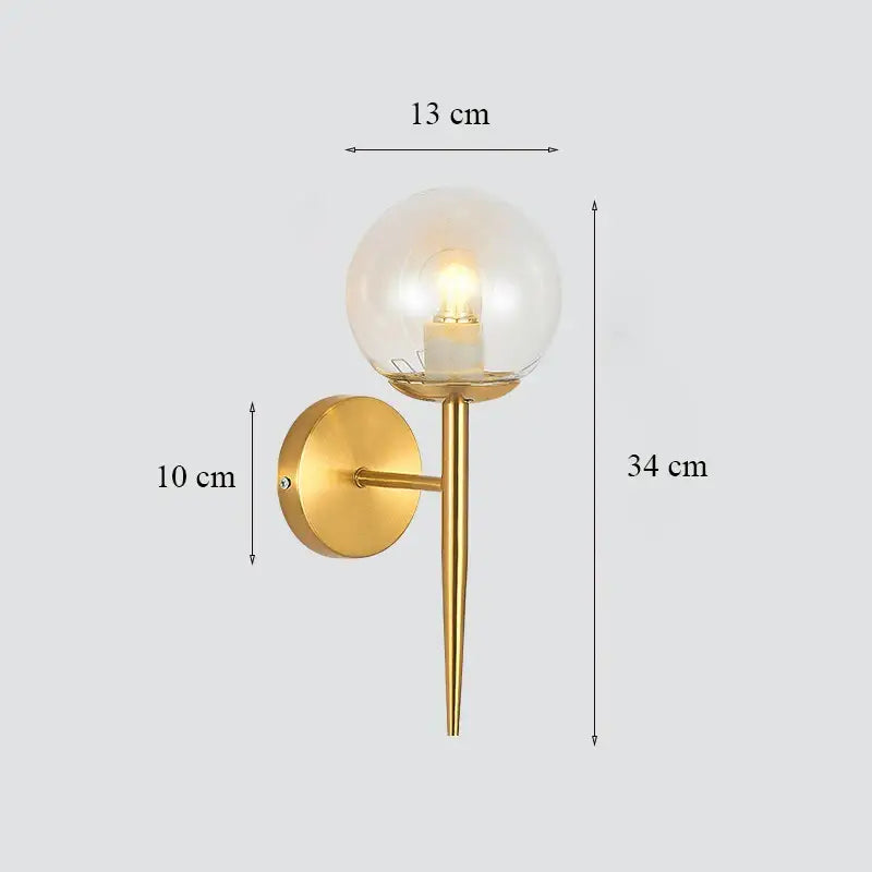 Classic brass glass wall sconce with gold-toned slender stem and clear glass globe for elegant bedroom decorbites brass glass lighting