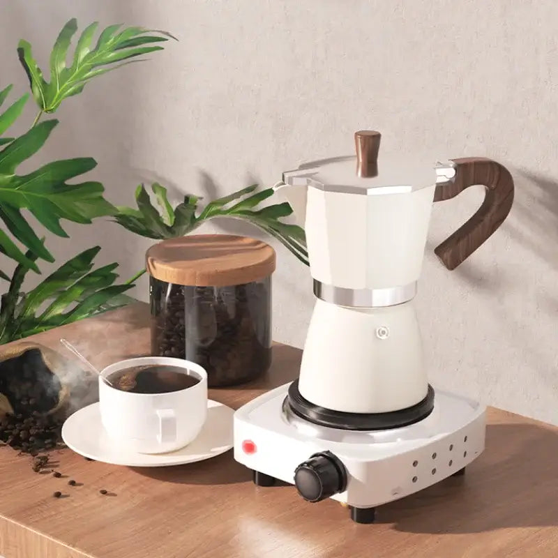 Classic cream aluminum moka pot coffee machine with dark wood handle on white electric hot plate for classic coffee