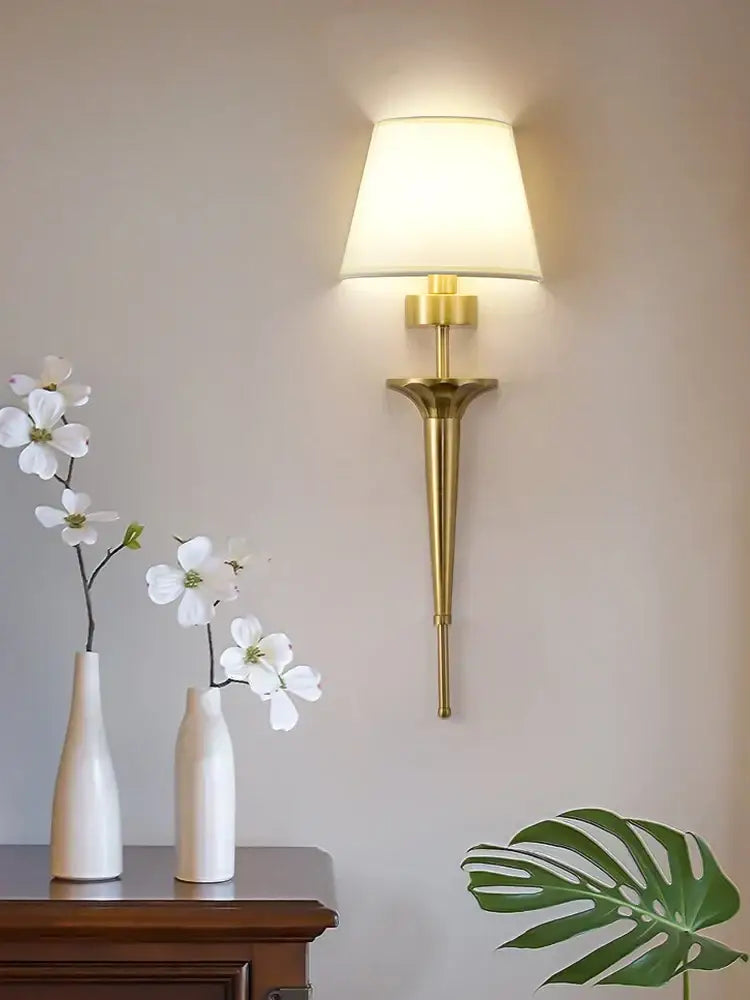 Classic gold fluted wall lamp with tapered stem and soft white fabric shade ideal for decorbites copper wall lamp settings