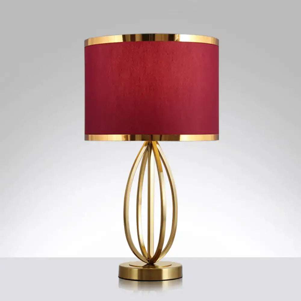 Elegant gold-toned metal round table lamp with deep red fabric shade accented by golden rims for study room use