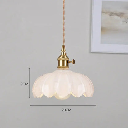 Classic glass white pendant light with brass hardware and fluted petal-like shade ideal for dining room lighting