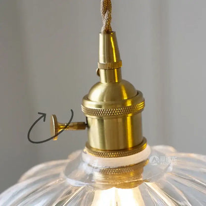 Brass-finished light fixture socket with textured bands and knurled knob in classic green glass flower pendant light hardware