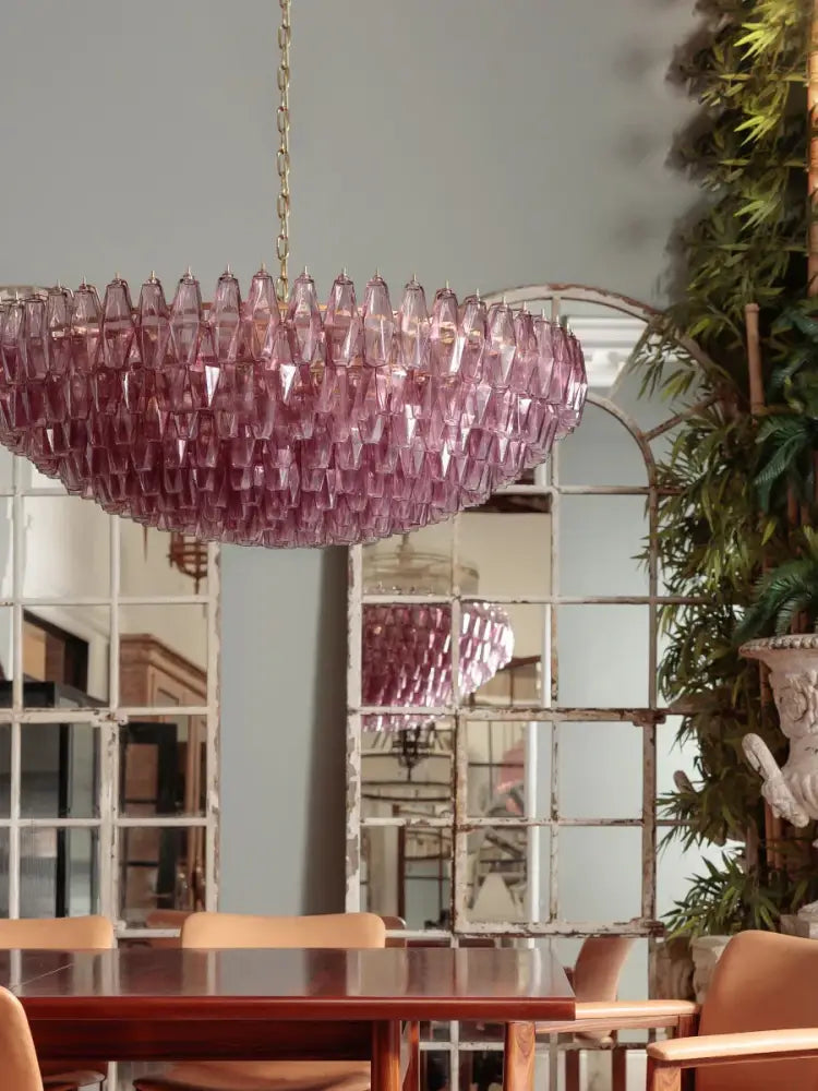 A large pink glass chandelier with teardrop design and gold chain for classic dining room lighting decorbites large pink