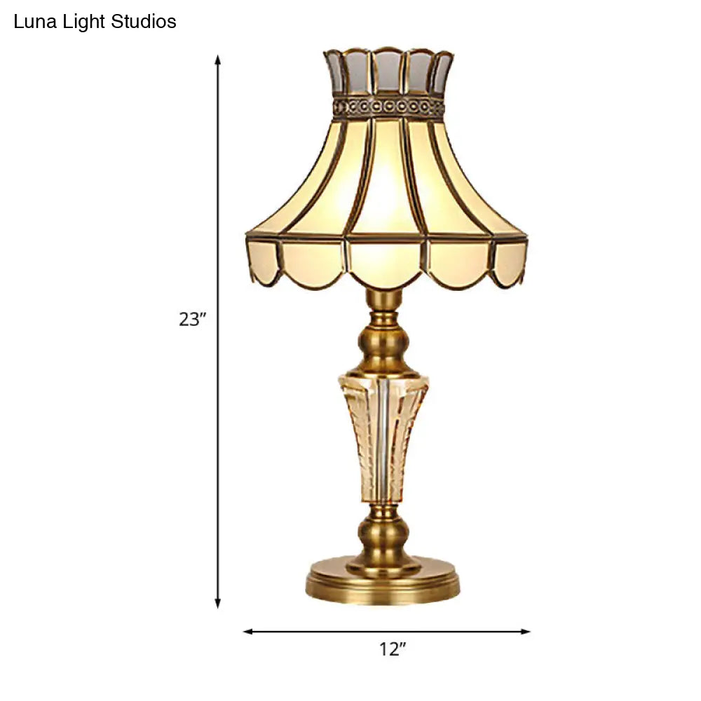 Lámpara de mesa de noche clásica con borde festoneado, acabado dorado y detalles de cristal.