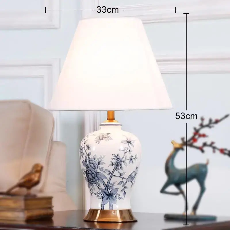 Classic white porcelain table lamp with blue floral bird motifs gold base and cream fabric shade for living room decor