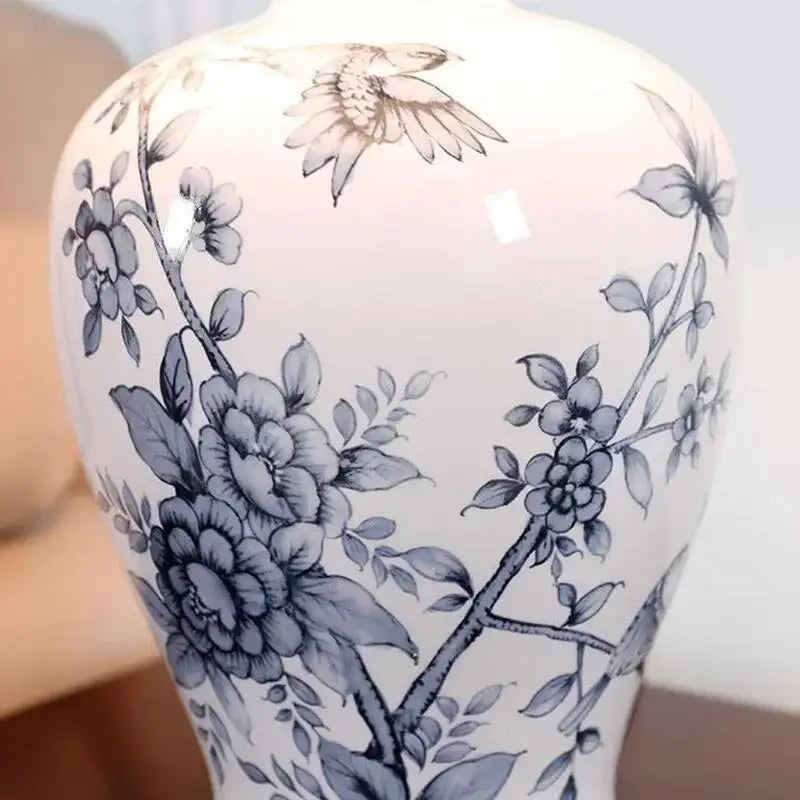 Classic white and black porcelain table lamp featuring a white ceramic base with blue and gray floral bird motifs