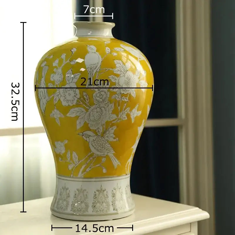 A vibrant yellow ceramic vase with intricate white floral and bird motifs featured as decorbites blue white porcelain decor
