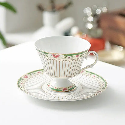 Elegant classical gold-striped ceramic cup and saucer set featuring white porcelain with pink floral and green leaf patterns
