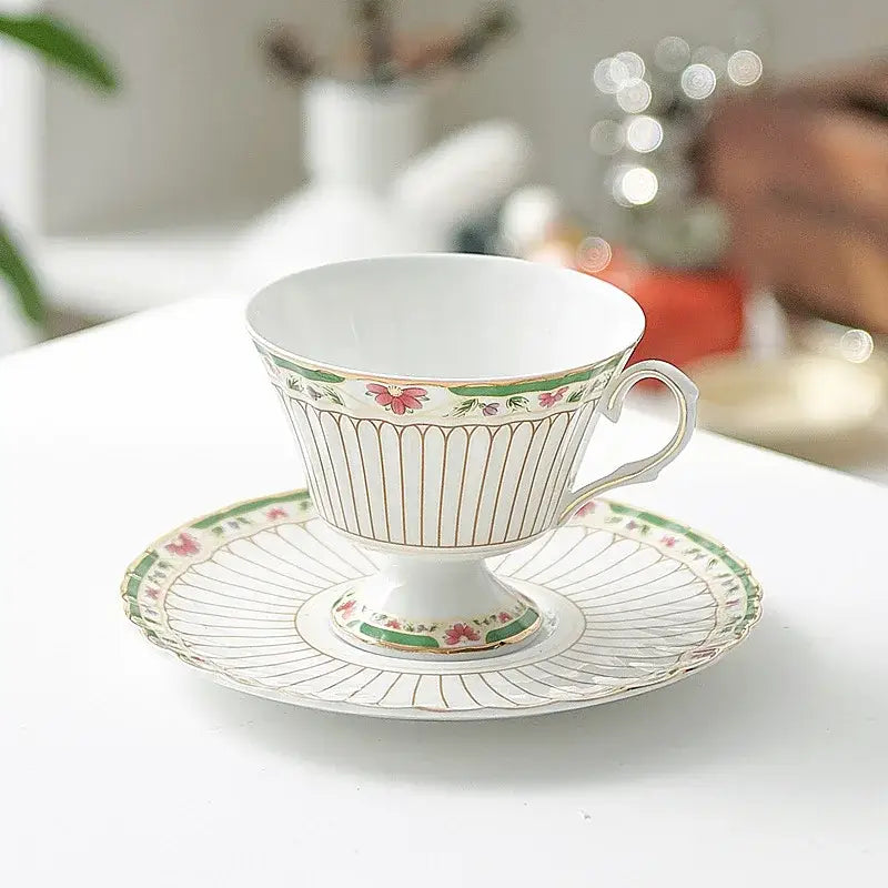 Elegant classical gold-striped ceramic cup and saucer set featuring white porcelain with pink floral and green leaf patterns
