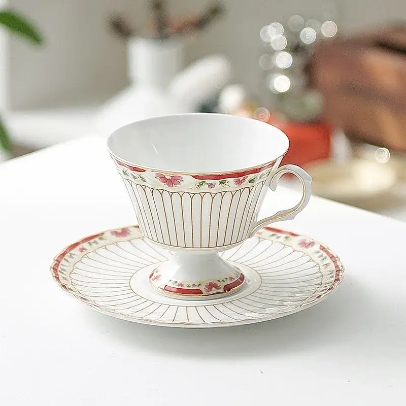 A delicate white porcelain classical gold-striped ceramic cup and saucer set with red floral accents for dining room use