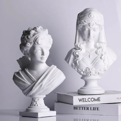 Two white classical cupid statue plaster bust sculptures with curly hair and floral veil for living room decor